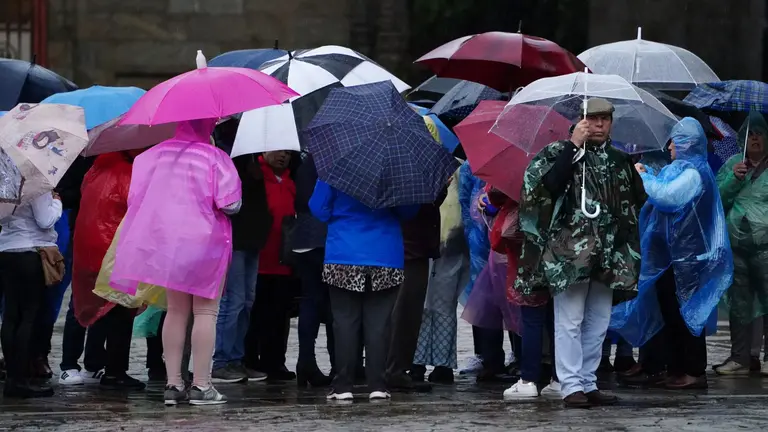 Varias personas se resguardan bajo un paraguas de la lluvia, el viento y el mal tiempo. &Aacute;LVARO BALLESTEROS / EUROPA PRESS