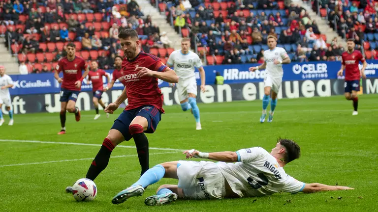 David Garc&iacute;a (5. CA Osasuna) y Miguel Guti&eacute;rrez (3. Girona FC) durante el partido de La Liga EA Sports entre CA Osasuna y Girona FC disputado en el estadio de El Sadar en Pamplona. I&Ntilde;IGO ALZUGARAY