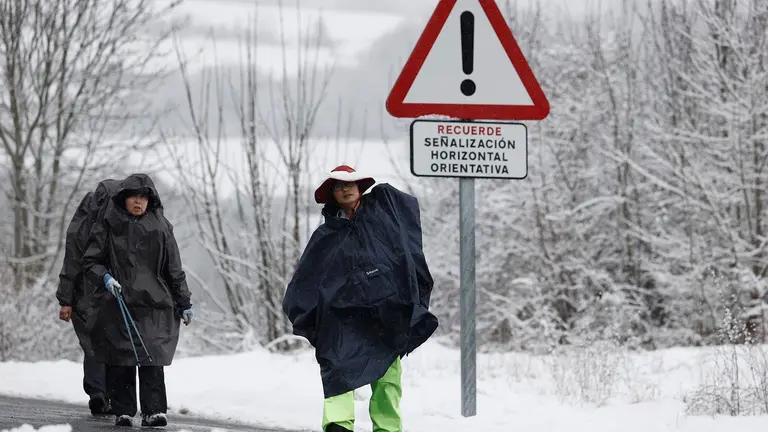 Un grupo de peregrinos koreanos realizan su camino por la carretera ante la imposibilidad de hacerlo por el camino original por la presencia de nieve en una jornada donde la normalidad es la nota dominante en las carreteras navarras a primeras horas de este miércoles en el que la Comunidad Foral está en alerta por nevadas. Así, tan solo son necesarias las cadenas para circular por la NA-137 Burgui-Isaba-Francia, puerto de Belagua, desde el kilómetro 51, desde el refugio. EFE/ Jesús Diges