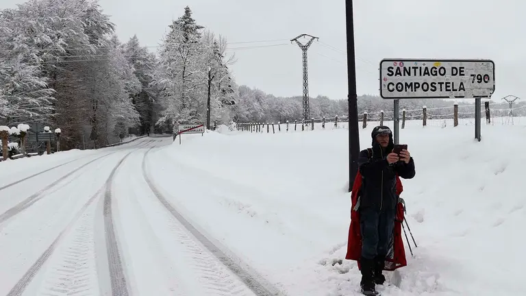 GRAFCAV7705. RONCESVALLES, 10/01/2024.- Un peregrino realiza su camino por la carretera ante la imposibilidad de hacerlo por el camino original por la presencia de nieve en una jornada donde la normalidad es la nota dominante en las carreteras navarras a primeras horas de este mi&eacute;rcoles en el que la Comunidad Foral est&aacute; en alerta por nevadas. As&iacute;, tan solo son necesarias las cadenas para circular por la NA-137 Burgui-Isaba-Francia, puerto de Belagua, desde el kil&oacute;metro 51, desde el refugio. EFE/ Jes&uacute;s Diges