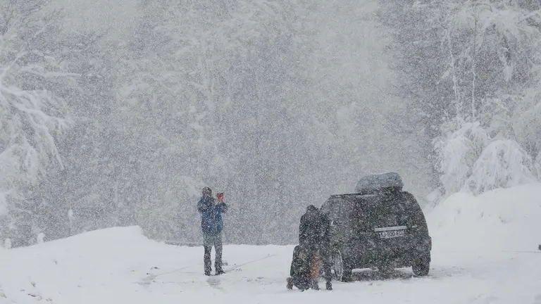 Un grupo de personas se toma una fotografía en el Alto de Ibañeta en una jornada donde la normalidad es la nota dominante en las carreteras navarras a primeras horas de este miércoles en el que la Comunidad Foral está en alerta por nevadas. Así, tan solo son necesarias las cadenas para circular por la NA-137 Burgui-Isaba-Francia, puerto de Belagua, desde el kilómetro 51, desde el refugio. EFE/ Jesús Diges