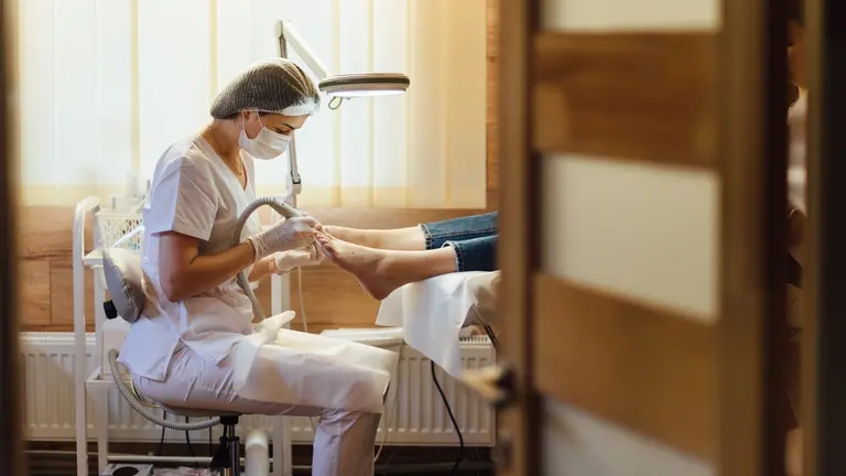 Una profesional atendiendo los pies de un paciente. CEDIDA UNIVERSIDAD DE EUNEIZ - SHUTTERSTOCK