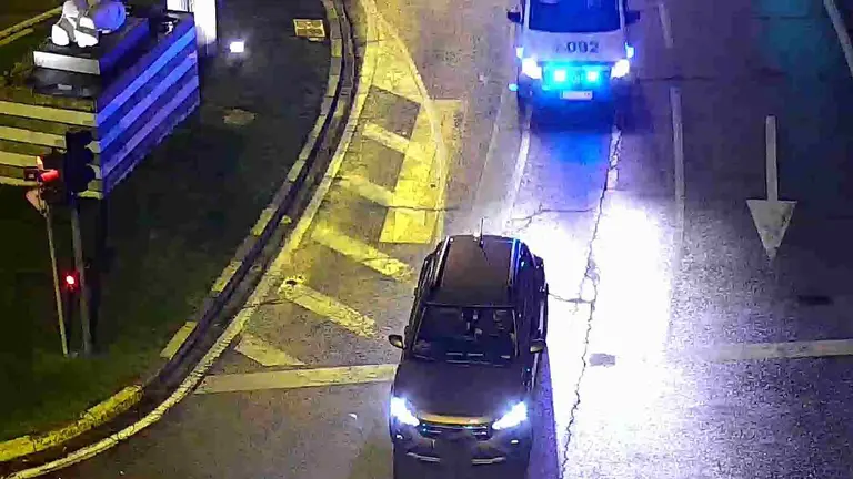 El coche parado en la Plaza de la Paz de Pamplona con el conductor dormido al volante y una coche patrulla detr&aacute;s. POLIC&Iacute;A MUNICIPAL DE PAMPLONA