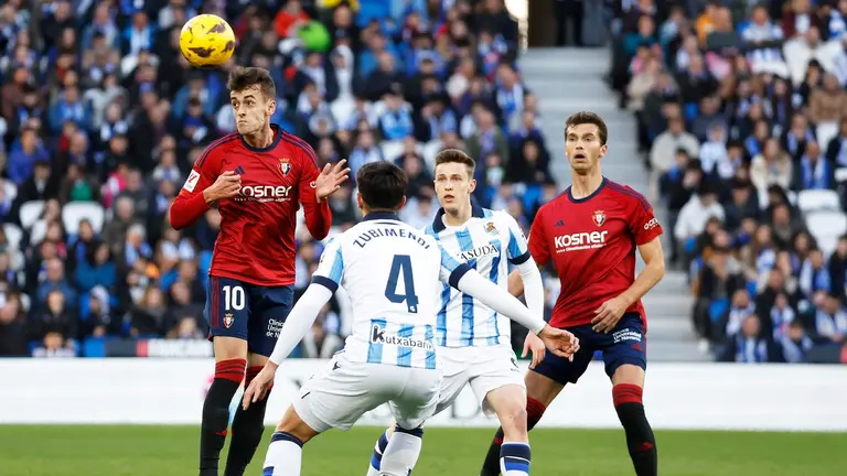 El centrocampista de la Real Sociedad Martín Zubimendi (c) y el centrocampista del Osasuna Aimar Oroz durante el partido de la jornada 24 de LaLiga que la Real Sociedad y el Osasuna disputan este sábado en el Real Arena de San Sebastián. EFE/ Javier Etxezarreta