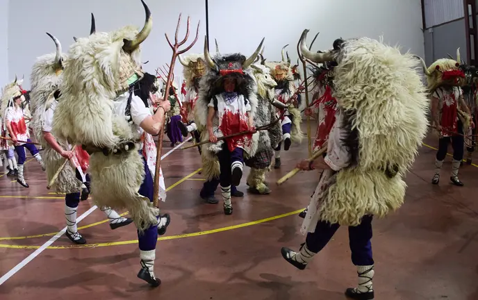 Los Momotxorros, niños y adultos, cubiertos de sangre de animal y ataviados con cuernos, pieles y su gran sarde de madera, recorren las calles de Alsasua al anochecer bailando y asustando a todo aquel que se cruce en su camino durante el carnaval rural de la localidad. IÑIGO ALZUGARAY