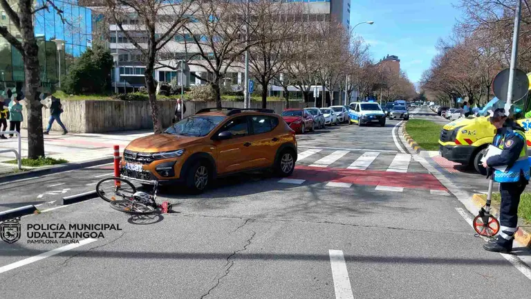 La bici siniestrada y el coche que la arroll&oacute; sobre el carril bici que cruza la calle Arcadio Mar&iacute;a Larraona en la rotonda de los Golem de Pamplona. POLIC&Iacute;A MUNICIPAL DE PAMPLONA