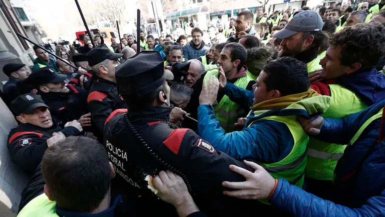 GRAFCAV9764. PAMPLONA, 07/03/2024.- Un grupo de agricultores ha tratado de acceder al interior del Parlamento de Navarra, lo que les ha sido impedido por la Policía Foral, en el momento en el que intervenía el portavoz socialista después de que se supiera que la Cámara no había admitido a trámite una enmienda de UPN que recogía sus demandas.EFE/ Jesus Diges