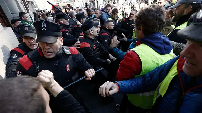 GRAFCAV9762. PAMPLONA, 07/03/2024.-  Un grupo de agricultores ha tratado de acceder al interior del Parlamento de Navarra, lo que les ha sido impedido por la Polic&iacute;a Foral, en el momento en el que interven&iacute;a el portavoz socialista despu&eacute;s de que se supiera que la C&aacute;mara no hab&iacute;a admitido a tr&aacute;mite una enmienda de UPN que recog&iacute;a sus demandas.EFE/ Jesus Diges