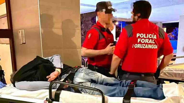 Dos agentes de la polic&iacute;a Foral custodian al presunto autor material de los disparos tras su detenci&oacute;n en Zizur Mayor. POLIC&Iacute;A FORAL