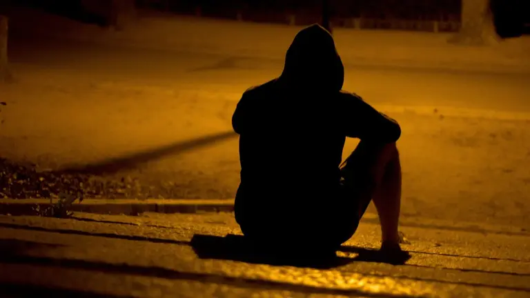 Imagen de archivo de un joven sentado por la noche. ARCHIVO