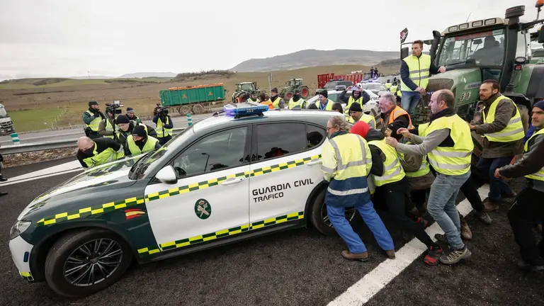 Imagen de archivo de los tractoristas zarandeando un coche de la Guardia Civil en unas movilizaciones en la Autov&iacute;a del Camino de Santiago. JES&Uacute;S DIGES / EFE