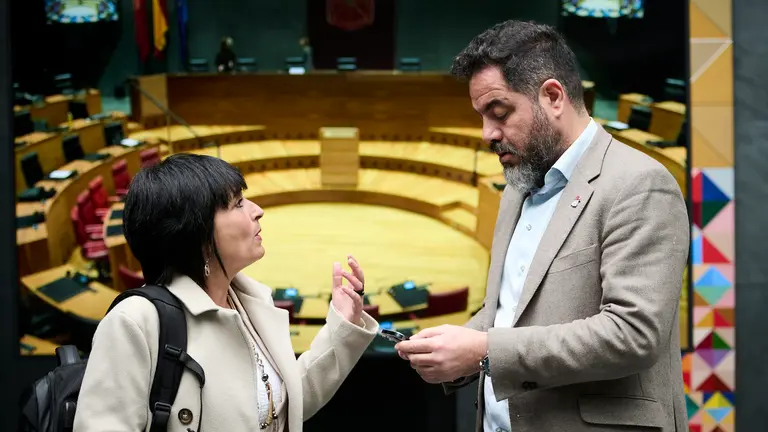 Laura Aznal de EH Bildu habla con Ram&oacute;n Alz&oacute;rriz, del PSN minutos antes de comenzar el pleno del Parlamento. PABLO LASAOSA