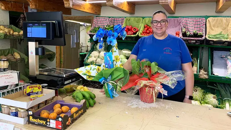 Carolina medina con las dos flores que le han regalado en su &uacute;ltimo d&iacute;a en la tienda Comestibles Ib&aacute;&ntilde;ez de Pamplona. Navarra.com