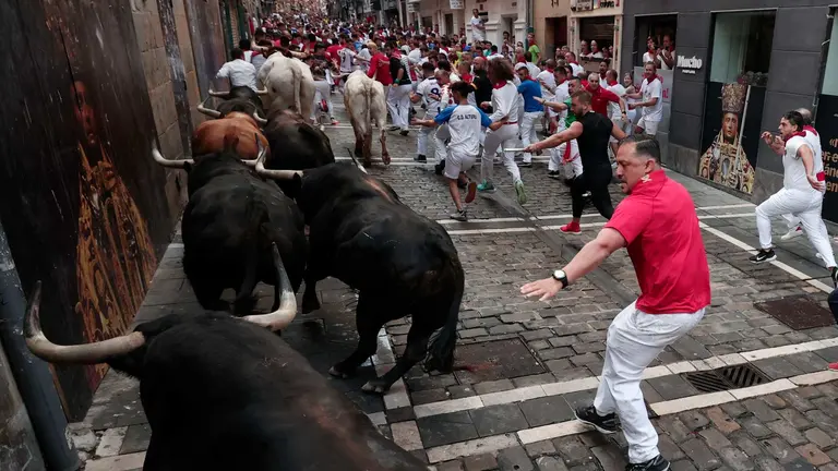 Los toros de la ganader&iacute;a de Fuente Ymbro pasan por la curva de Mercaderes y enfilan la calle de la Estafeta en el cuarto encierro de los Sanfermines este mi&eacute;rcoles, en Pamplona. EFEJes&uacute;s Diges