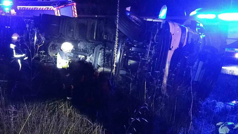 Bomberos de Navarra trabajan en la retirada del cami&oacute;n de la calzada. BOMBEROS