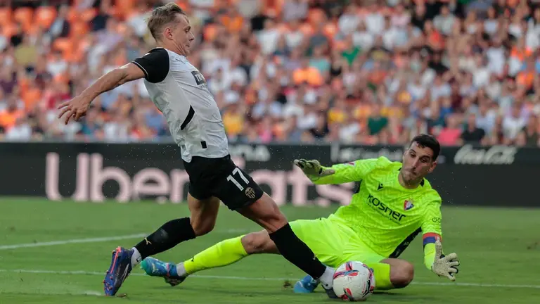 El guardameta del Osasuna Sergio Herrera (d) intenta frenar el avance del delantero del Valencia CF Dani G&oacute;mez (i) durante el encuentro correspondiente a la s&eacute;ptima jornada de LaLiga EA Sports que enfrenta al Valencia CF y al Osasuna en el estadio de Mestalla en Valencia, este martes. EFE/ Biel Ali&ntilde;o
