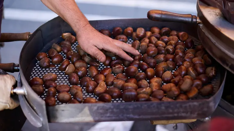 Míkel Álvarez en su puesto de castañas en la plaza de San Nicolás en Pamplona. PABLO LASAOSA.