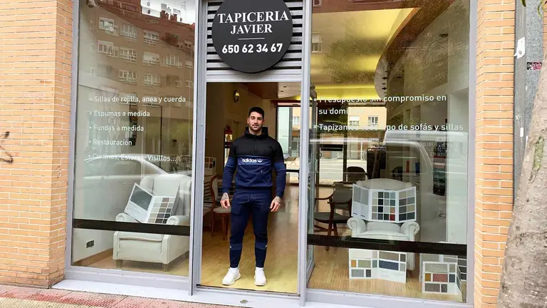 Brian Jim&eacute;nez en la puerta de la tapicer&iacute;a Javier en la Plaza Berr&iacute;a de Anso&aacute;in. Navarra.com