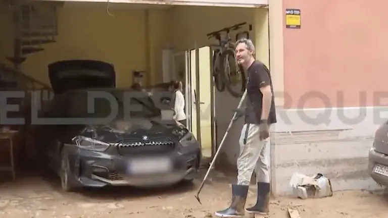 Imagen del entrenador de Osasuna, Vicente Moreno, achicando agua de un garaje en Massanassa. EL DESMARQUE