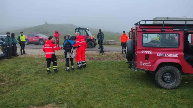 Bomberos, Guardia Civil y Polic&iacute;a Foral han participado en el dispositivo de b&uacute;squeda. En la imagen, los bomberos acompa&ntilde;an al monta&ntilde;ero perdido tras encontrarlo. BOMBEROS DE NAVARRA