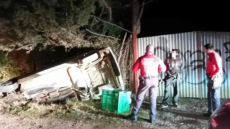 Dos agentes de la Polic&iacute;a Foral con el conductor que se dio a la fuga ante el coche volcado. POLIC&Iacute;A FORAL