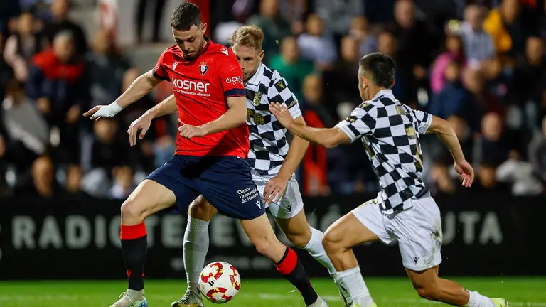 Aisar Ahmed (d) del Ceuta disputa un balón con Raúl García (i) del Osasuna este jueves, durante un partido de segunda ronda de Copa del Rey, entre el AD Ceuta y el Osasuna, en el Estadio Alfonso Murube de Ceuta. EFE/ Jorge Zapata