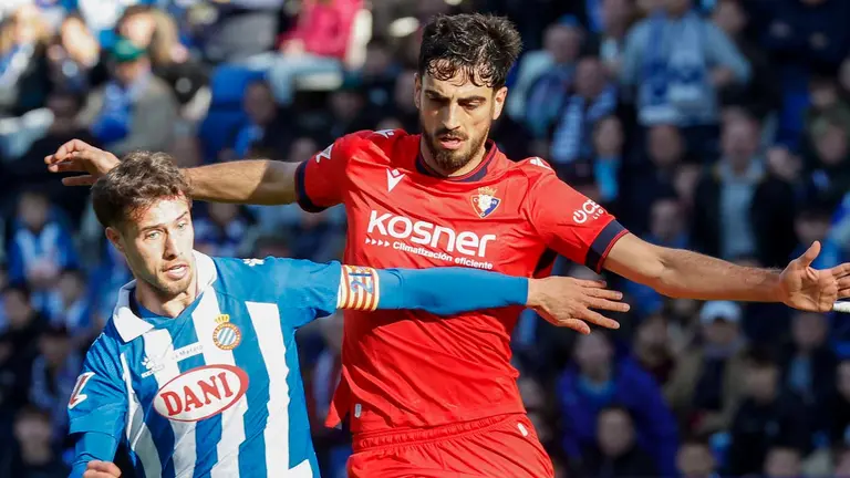 Javi Puado (i), del Espanyol, se enfrenta a Alejandro Catena (d), del Osasuna, durante su partido de la jornada 17 LaLiga de fútbol, este sábado en el RCDE Stadium, en Cornellà de Llobregat (Barcelona). EFE/ Andreu Dalmau