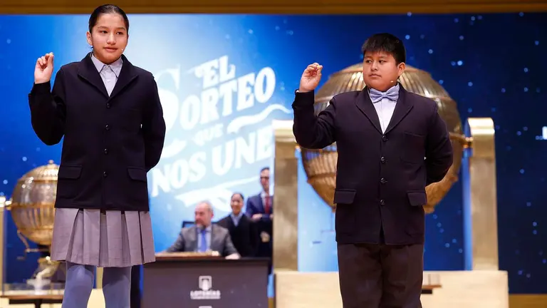 Los niños de la Residencia San Ildefonso de Madrid Piero Rai Chávez (d) y Alisce Ríos (i), muestran el número 48.020, otro cuarto premio dotado con 200.000 euros a la serie, durante el sorteo de la Lotería de Navidad que se celebra este domingo en el Teatro Real, en Madrid. EFE/Javier Lizón