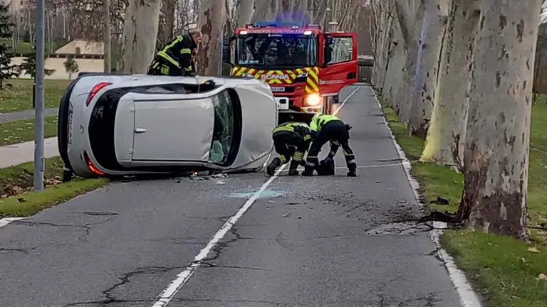 El coche ha quedado volcado sobre la calzada de la carretera de la Universidad. POLICÍA MUNICIPAL DEPAMPLONA