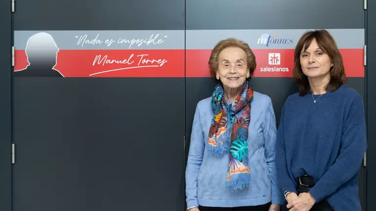 Amparo Lusarreta y Yolanda Torres ante la puerta del Aula Manuel Torres destacada co
el lema del propio Manuel Torres: Nada es imposible. CEDIDA