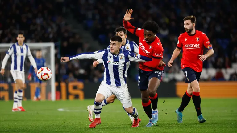 El centrocampista de la Real Sociedad Ander Barrenetxea (i) intenta escaparse de Flavien-Enzo Boyomo, de Osasuna, durante el partido de cuartos de final de la Copa del Rey que Real Sociedad y CA Osasuna disputan este jueves en el Reale Arena de San Sebastián. EFE/ Javier Etxezarreta
