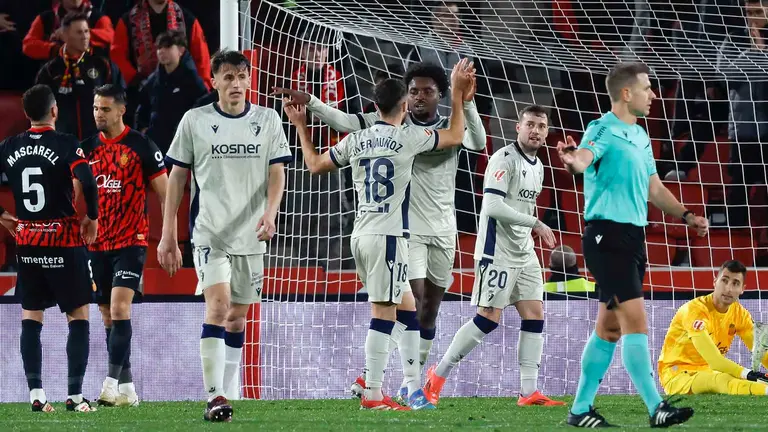 Los jugadores de Osasuna, Iker Muñoz y el camerunés Flavien-Enzo Boyomos, celebran el primer gol de su equipo durante el encuentro correspondiente a la jornada 23 de Laliga EA Sports que disputan hoy lunes RCD Mallorca y Osasuna en el estadio de Son Moix, en la capital balear. EFE/CATI CLADERA.