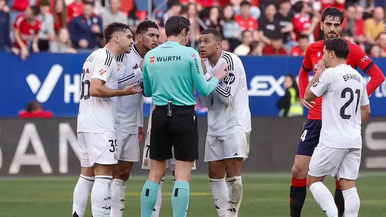 El delantero franc&eacute;s del Real Madrid Kylian Mbapp&eacute; y su compa&ntilde;ero el delantero ingl&eacute;s Jude Bellingham conversan con el el colegiado Munuera Montero, durante el partido de la jornada 24 de la LaLiga EA Sports, disputado este s&aacute;bado en el estadio el Sadar de Pamplona. EFE/ Villar Lopez