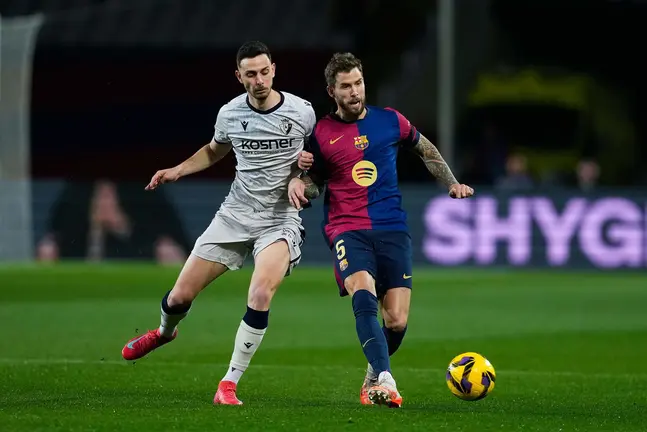 BARCELONA, 27/03/2025.- El defensa del F.C. Barcelona Iñigo Martínez (d) disputa un balón con el delantero del Osasuna Raúl García durante el partido de LaLiga entre FC Barcelona y CA Osasuna en el Estadio Olímpico de Montjuic, este jueves en Barcelona. EFE/ Alejandro Garcia