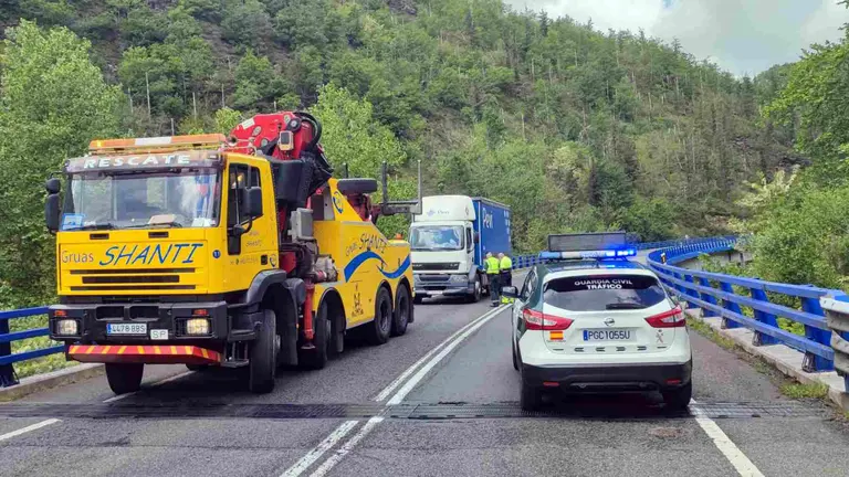 El cami&oacute;n accidentadoy la gru&aacute; que ha acudido a retirarlo ante el coche patrulla de la Guardia Civil. GUARDIA CIVIL DE NAVARRA