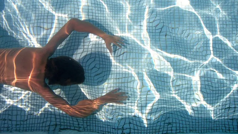 Una persona en una piscina en verano. PIXABAY