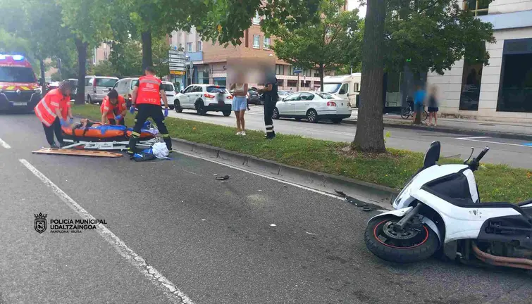 Sanitarios de Bomberos de Navarra atienden al motorista herido. POLIC&Iacute;A MUNICIPAL DE PAMPLONA