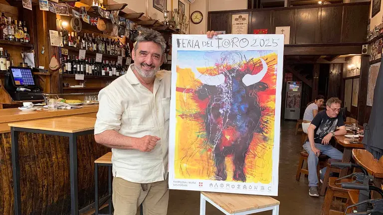 Manuel Sagüés con el cartel de la Feria del Toro 2025 en el bar La servicial de Pamplona. Navarra.com