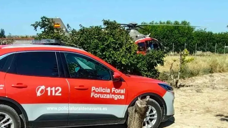 El helicóptero del Gobierno de Navarra ante un coche patrulla de la Policía Foral. POLICÍA FORAL