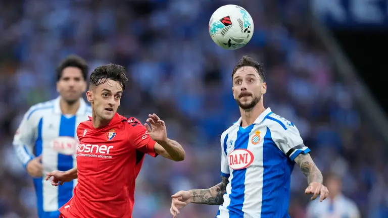 El defensa del Espanyol Fernando Calero (d) lucha con Aimar Oroz, de Osasuna, durante el partido de la tercera jornada de LaLiga que RCD Espanyol y Atlético Osasuna juegan este domingo en el RCDE Stadium. EFE/Enric Fontcuberta