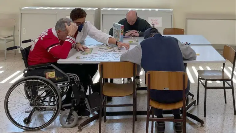 Mateo Bartollini ayuda a completar un puzzle con uno de los pacientes. CEDIDA