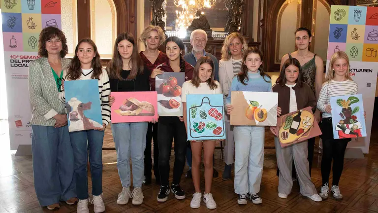 En la primera fila las ganadoras y finalistas del Concurso de Pintura de la Semana de Producto Local, con sus obras. De izquierda a derecha: Alaia Morala, Lua Aguirre, June Aranda, Martina Garc&iacute;a, June Acha y Julia Lara. En la segunda fila, los organizadores y miembros del jurado. De izquierda a derecha: Ana Irurita, Concha Pasamar, Pedro Salaberri, Isabel Pueyo y Suana Orduna. CRISTINA N&Uacute;&Ntilde;EZ