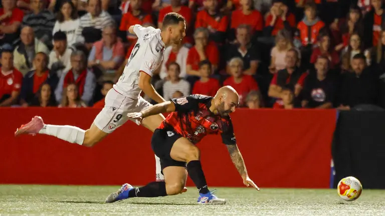 El defensa del Sant Jordi Jos&eacute; Custodio (dcha) pelea un bal&oacute;n con el delantero del Osasuna Raul Garc&iacute;a, durante el partido de primera ronda de la Copa del Rey que disputan este mi&eacute;rcoles en Palma. EFE/Cati Cladera