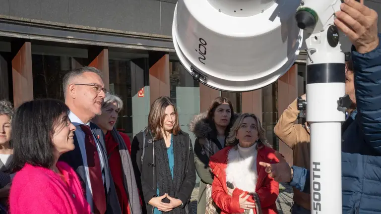 El consejero Garc&iacute;a y participantes en el acto observan un SUN-GUN, un telescopio solar especial para observar el eclipse.  GOBIERNO DE NAVARRA