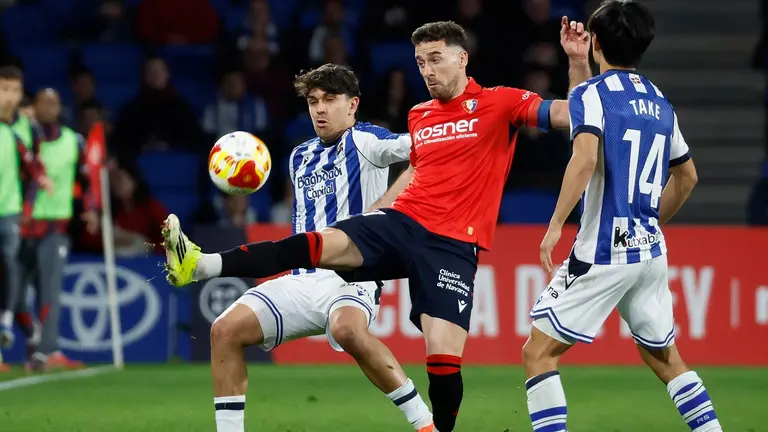 El defensa de la Real Sociedad Jon Aramburu (i) lucha con Kike Barja (c), de Osasuna, durante el encuentro correspondiente a los octavos de final de la Copa del Rey que disputan Real Sociedad y Atl&eacute;tico Osasuna hoy martes en el estadio de Anoeta, en San Sebasti&aacute;n. EFE/ Javier Etxezarreta.