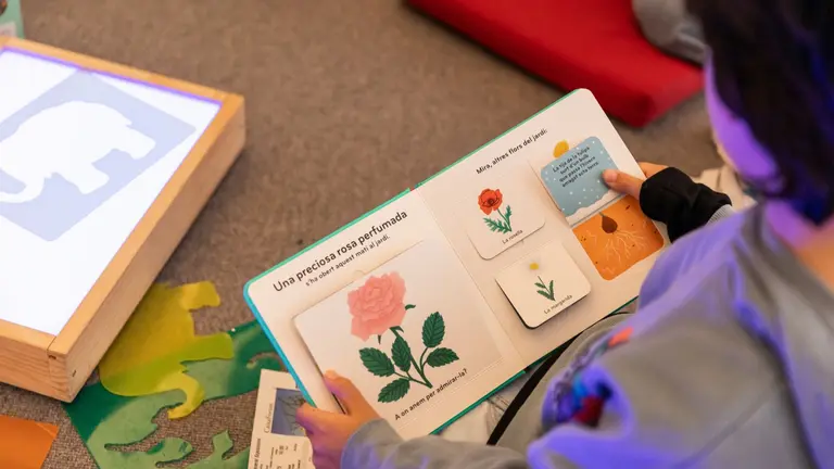 Un ni&ntilde;o sentado leyendo atentamente un libro. FUNDACI&Oacute;N LA CAIXA
