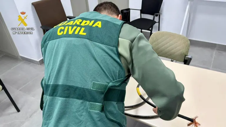 Un agente inspecciona el cable de cobre incautado. GUARDIA CIVIL