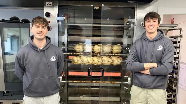 Pablo Orcoyen y Javier Aristu junto a la m&aacute;quina que asa los pollos en su local de Lezkairu en Pamplona. Navarra.com