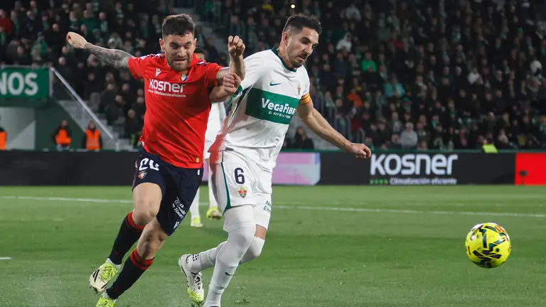 El defensa del Elche, Pedro Bigas (d), disputa el bal&oacute;n ante el defensa de Osasuna, Javi Gal&aacute;n, durante el encuentro correspondiente a la jornada 24 de Laliga EA Sports que disputan este Viernes Elche y Osasuna en el estadio Mart&iacute;nez Valero, en la localidad alicantina. EFE / Pablo Miranzo.