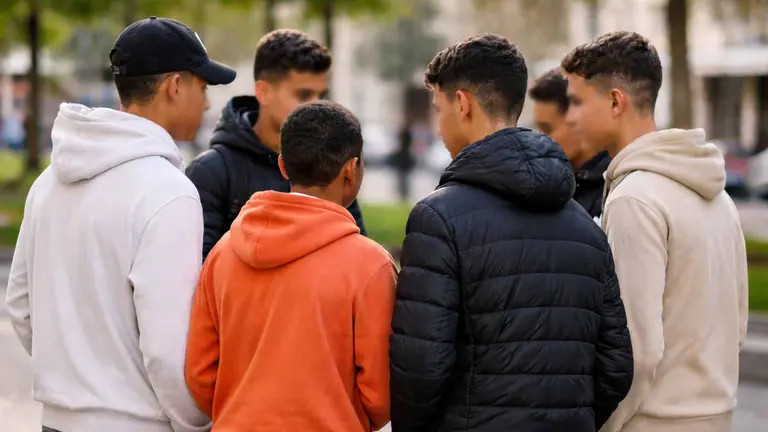 Un grupo de menas charlando en un parque.